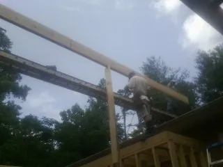 Carpenter setting a ridge beam over a new addition frame — Ice Dam Removal by Roofing Brothers in Maryland Line
