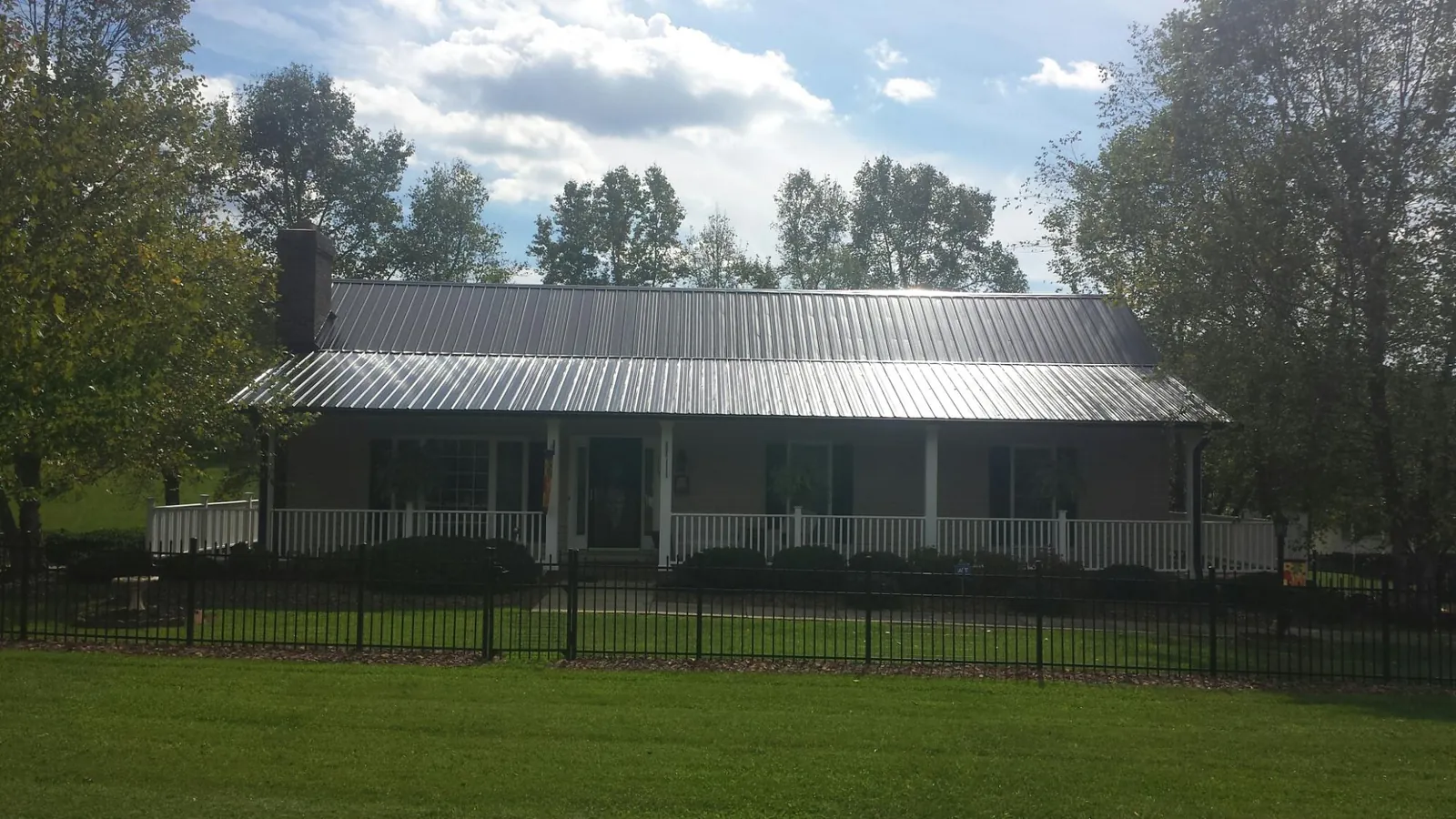 Gray metal roof on a brick ranch with a full width front porch — Gutter Guard Installation work by our crew in Maryland Line
