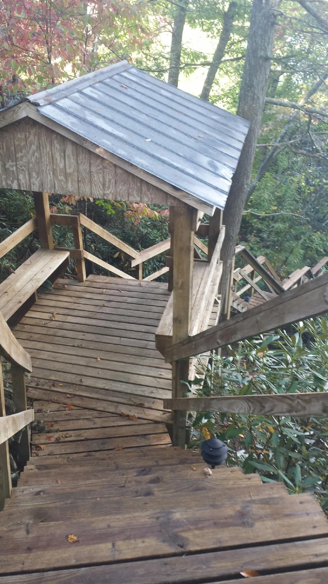 Metal roofed shelter over wooden steps on a wooded walkway — Skylight Repair & Installation work by our crew in Maryland Line