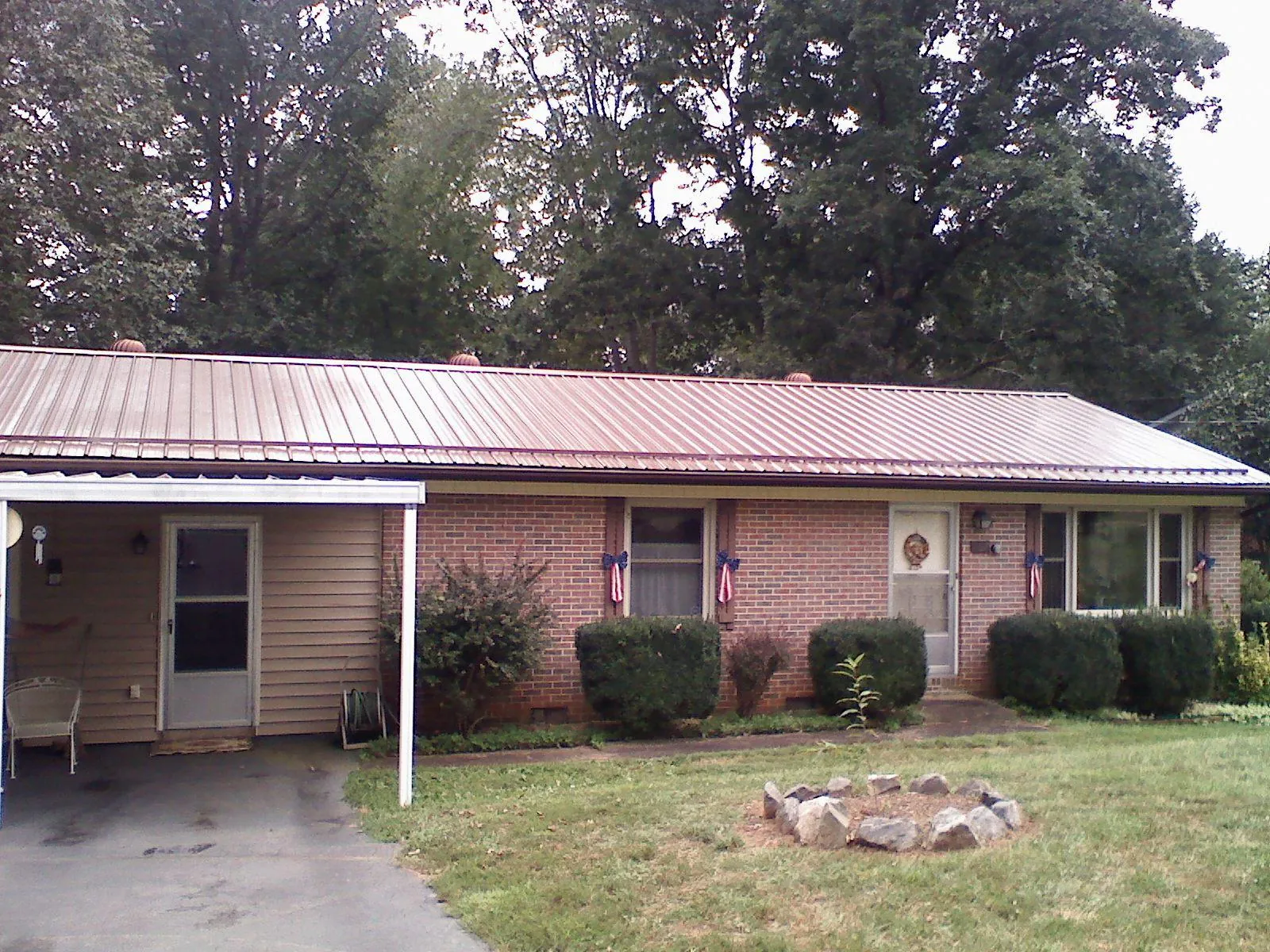Bronze metal roof and carport on a brick ranch home — Roof Repair work by our crew in Maryland Line