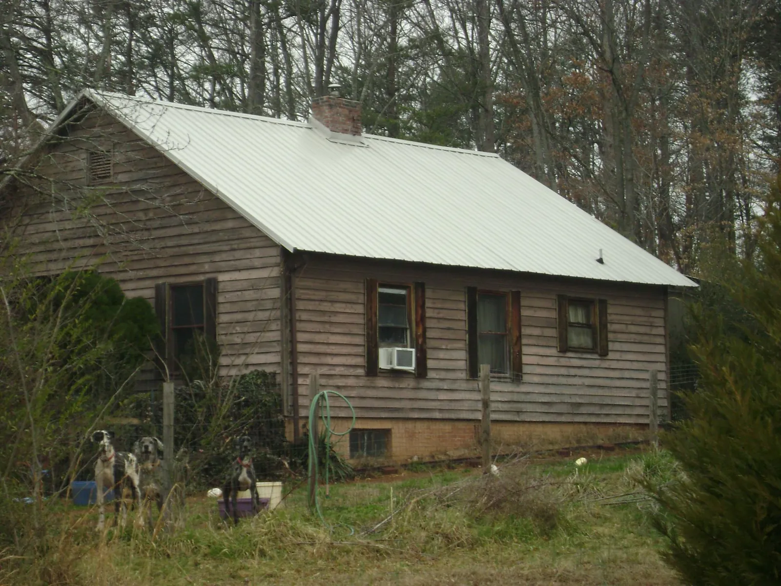 White metal roof on an old wood sided farmhouse, from a Metal Roof Installation job in Maryland Line